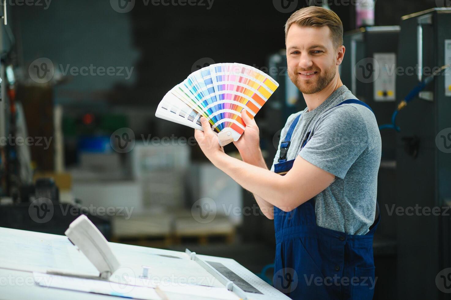 Funny portrait of typographer standing with color swatches at the printing manufacturing photo