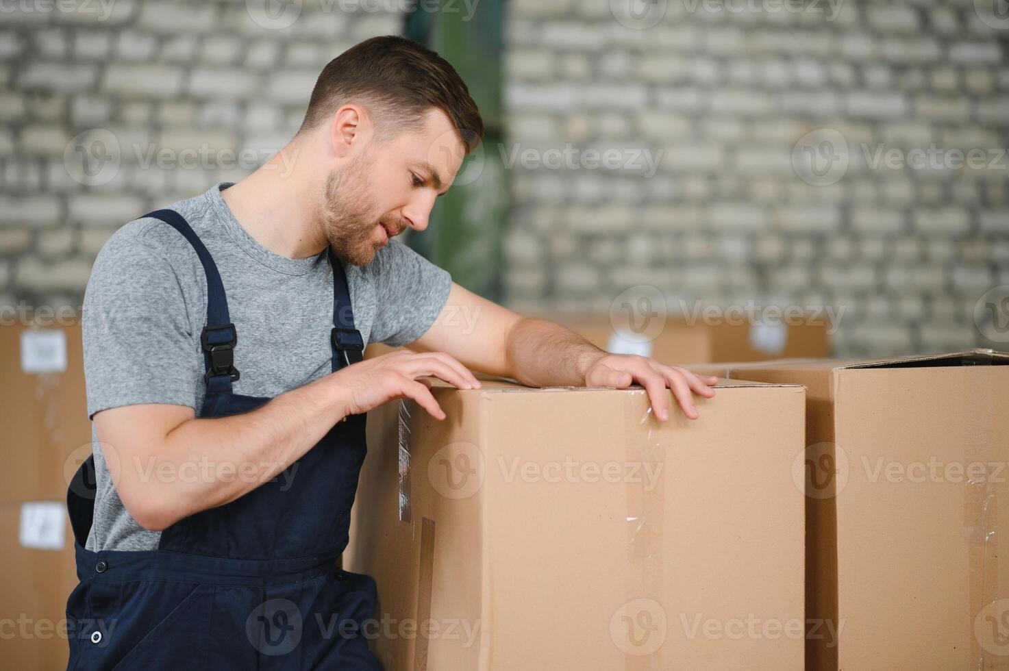 Warehouse worker carrying a carton for delivery to production stock. photo