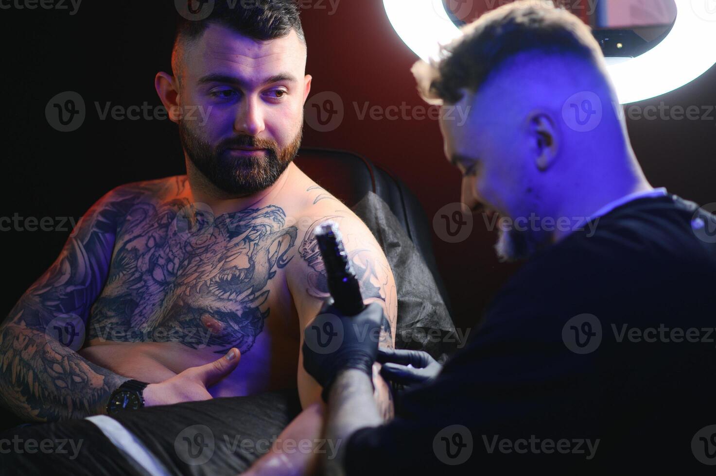 Tattoo artist hands wearing gloves and holding a tattoo machine photo