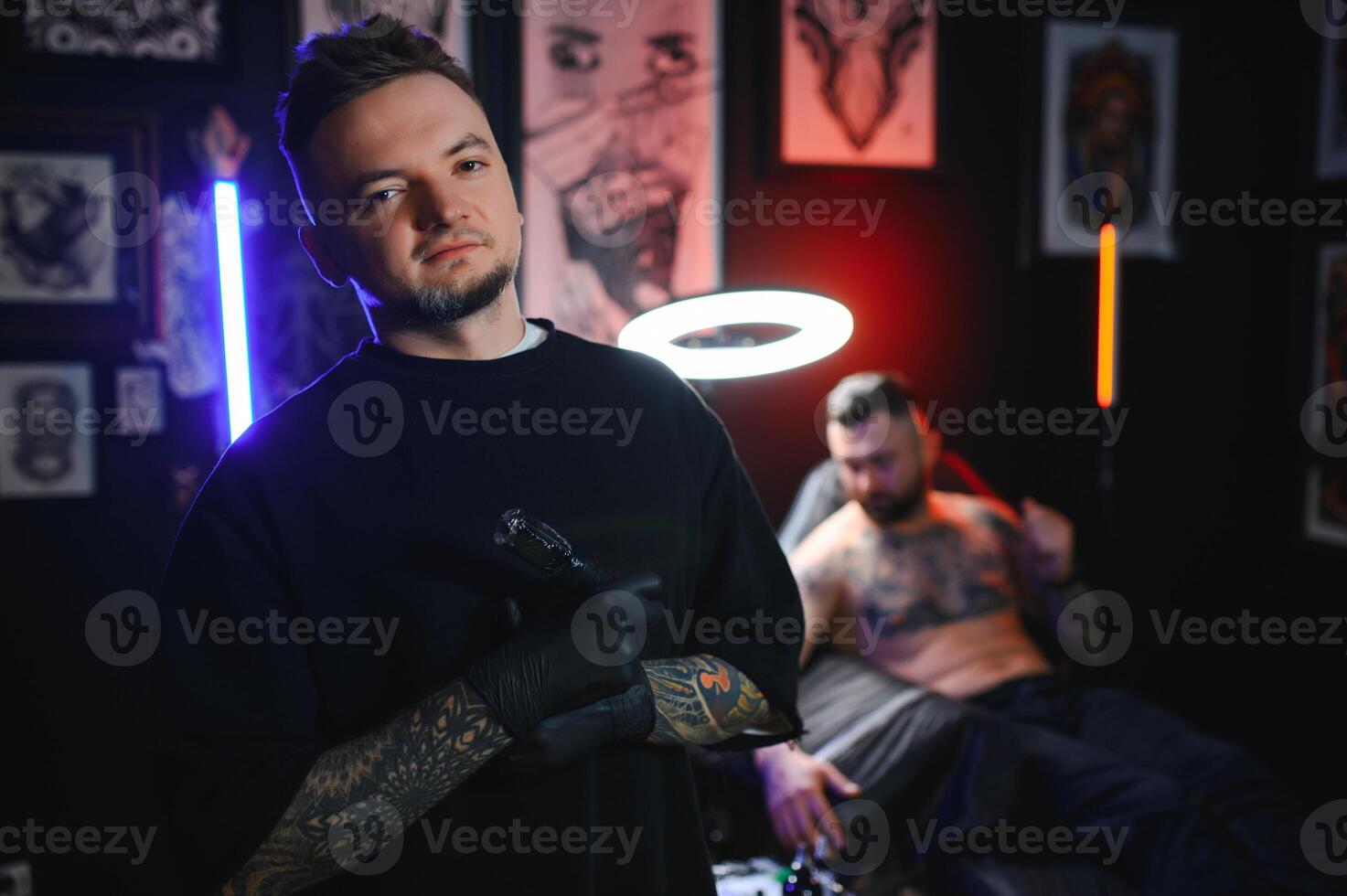 tattoo artist demonstrates the process of getting black tattoo with paint. Master works in black sterile gloves photo