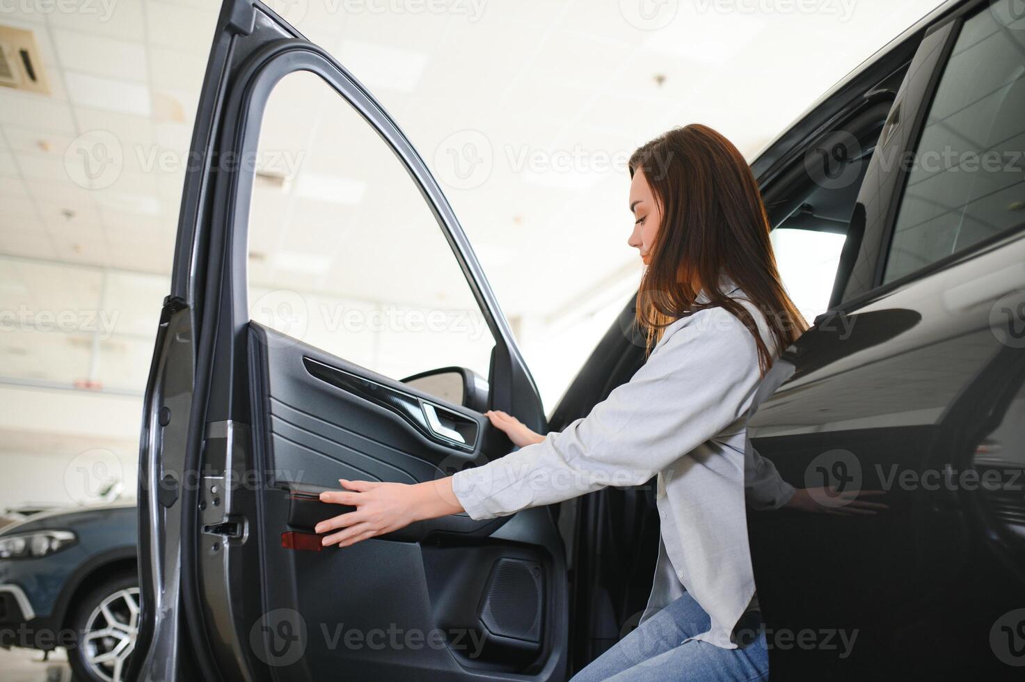 Happy friendly woman customer female buyer client chooses auto wants to buy new automobile photo