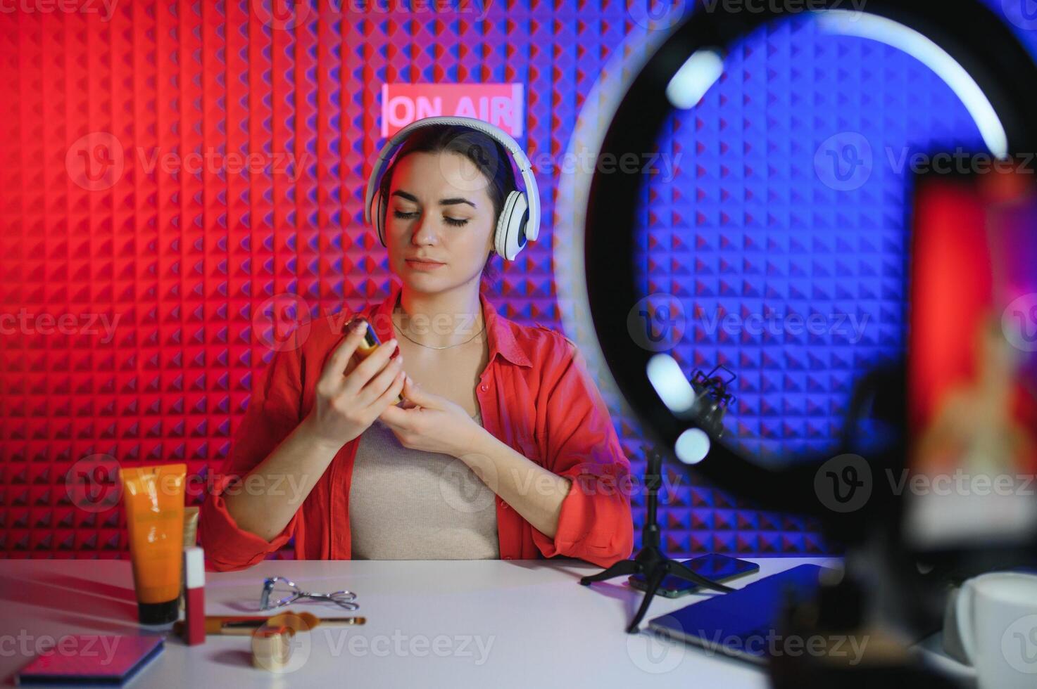 Famous blogger. Cheerful female vlogger is showing cosmetics products while recording and giving advices for her beauty blog photo