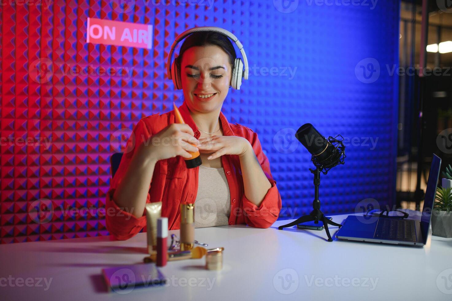 Beauty blogger woman filming daily make-up routine tutorial near camera on tripod photo