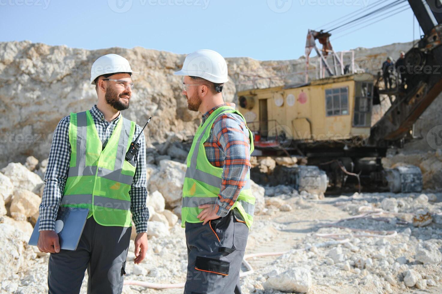 Two workers and quarry in background photo