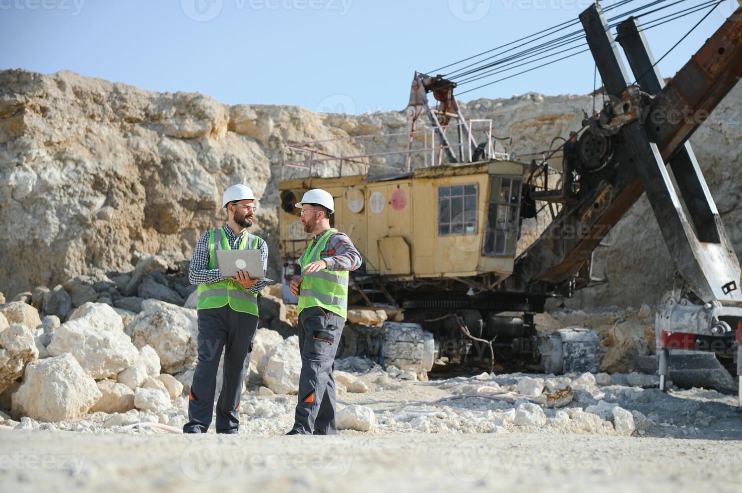 Two workers and quarry in background photo