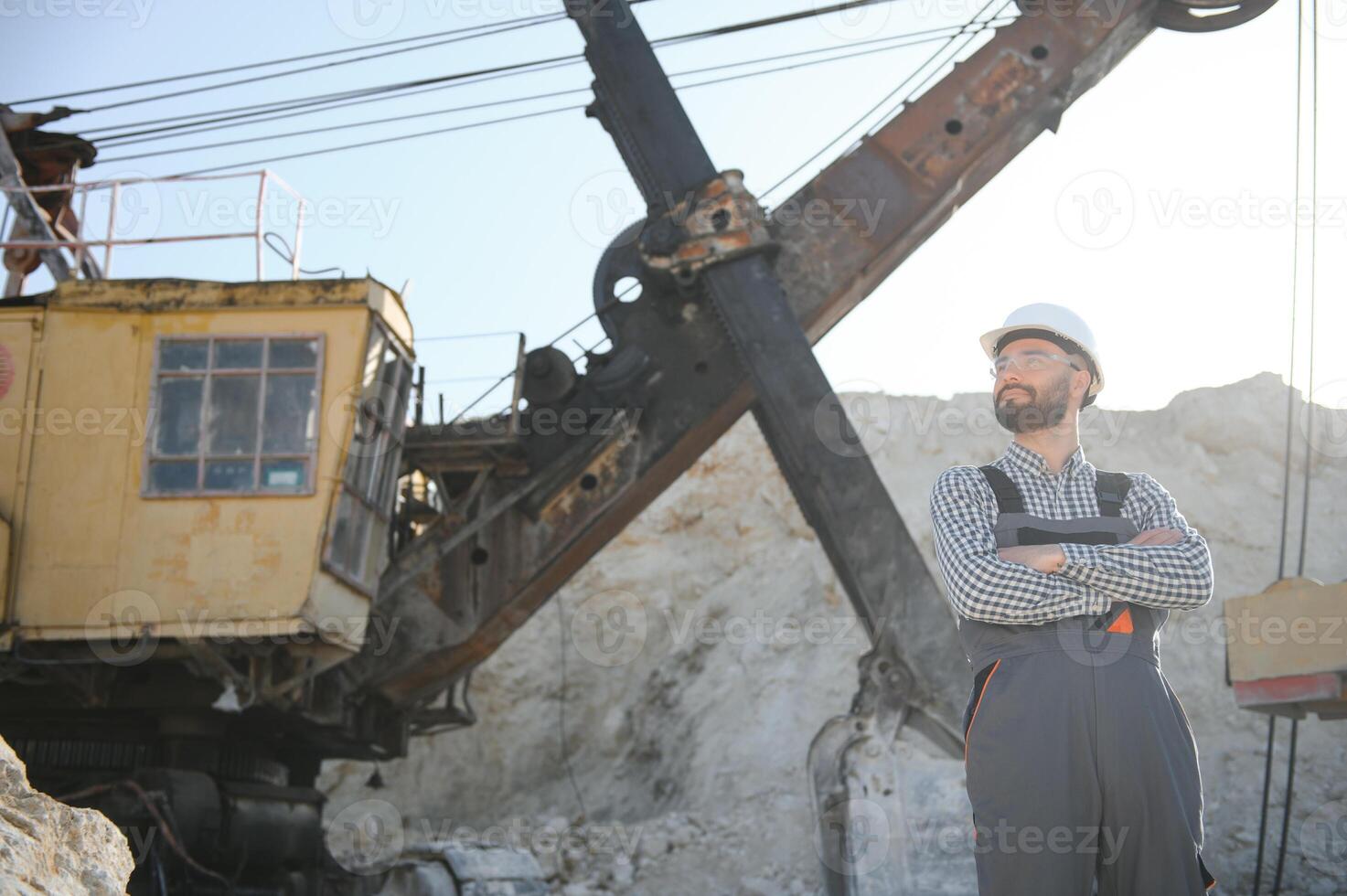 Worker in hardhat standing in stone quarry photo