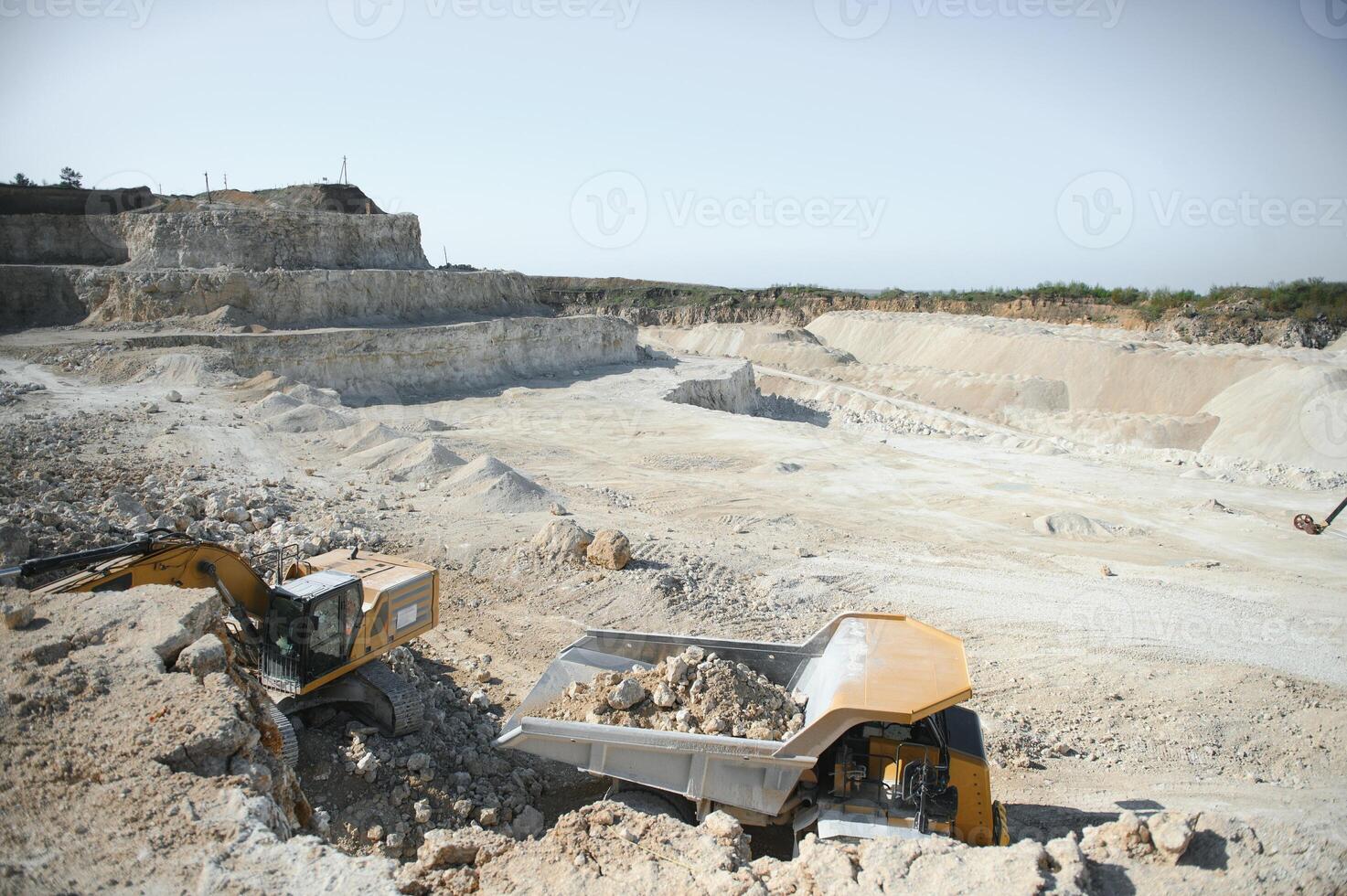 Heavy mining truck and excavator, close-up, against the background of the panorama of a limestone quarry photo