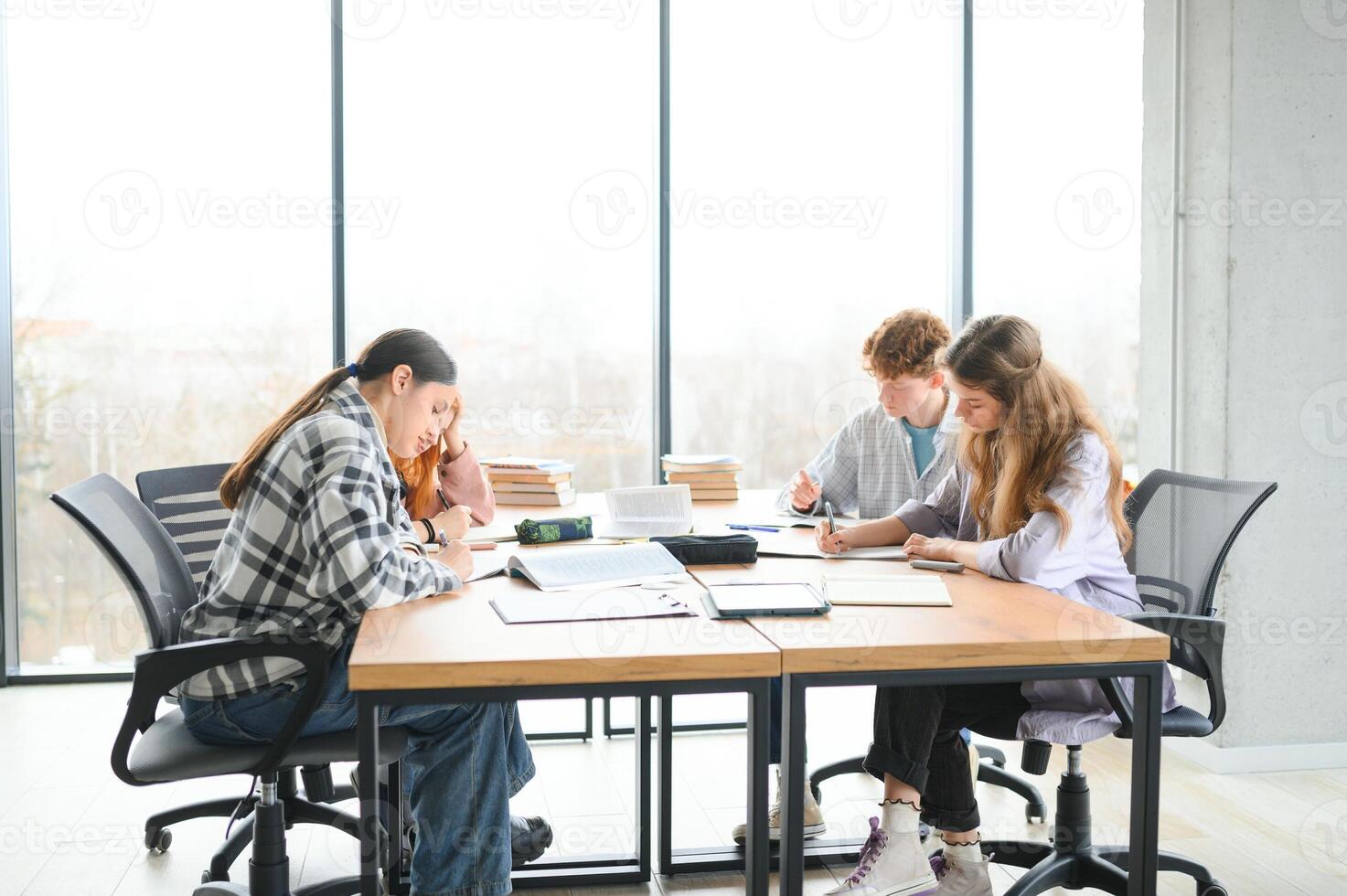 Happy group of friendly students talking, discussing new school project ideas together photo