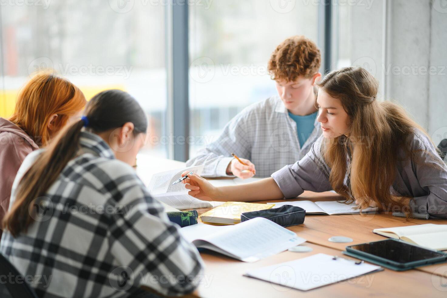 Testing. Closeup of young students sitting in a row and having test in their test-books photo