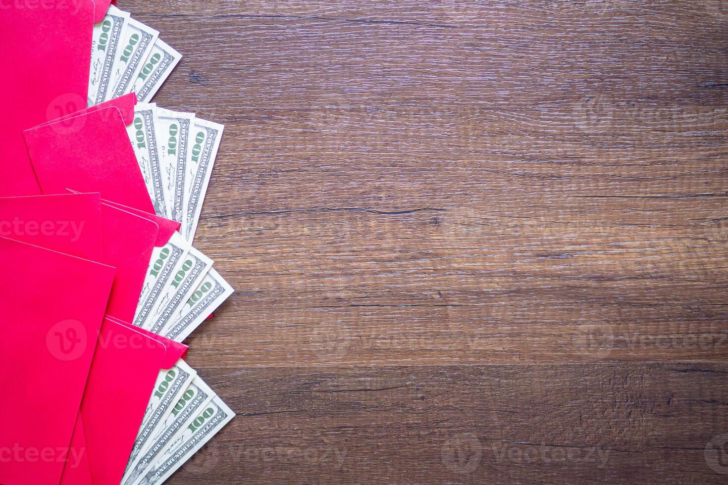 Red envelopes with money dollars prepare for given to children in Chinese New Year. Wooden table background and space for text. Festival concept photo