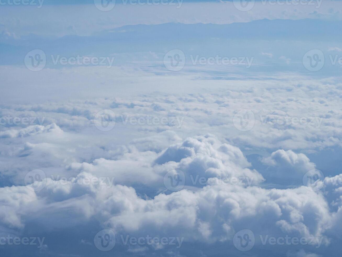 Aerial view of clouds and sky seen through the airplane window photo