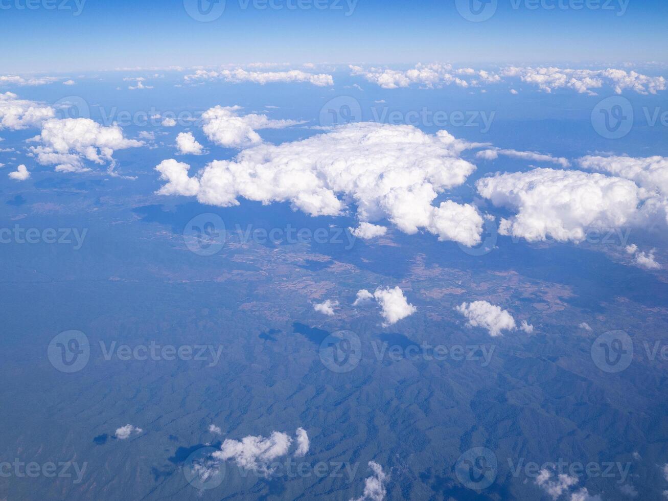 Aerial view of lands and clouds seen through the airplane window photo