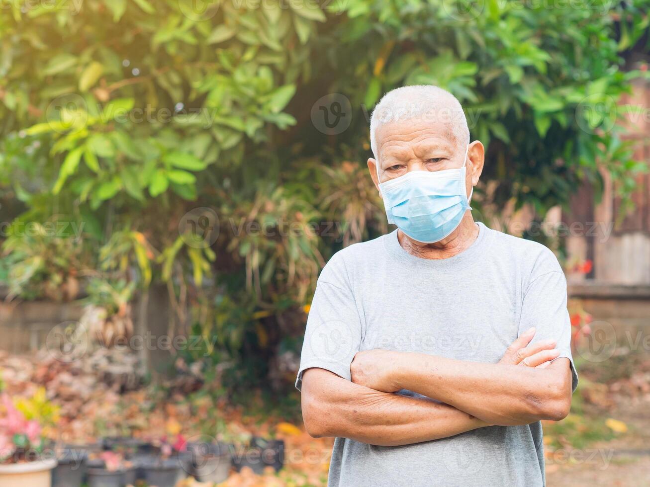 Portrait of an elderly man with short white hair, wearing a face mask for protecting virus, covid-19, coronavirus, bacteria, pollen grains, air pollution PM 2.5, and more. Healthcare concept photo