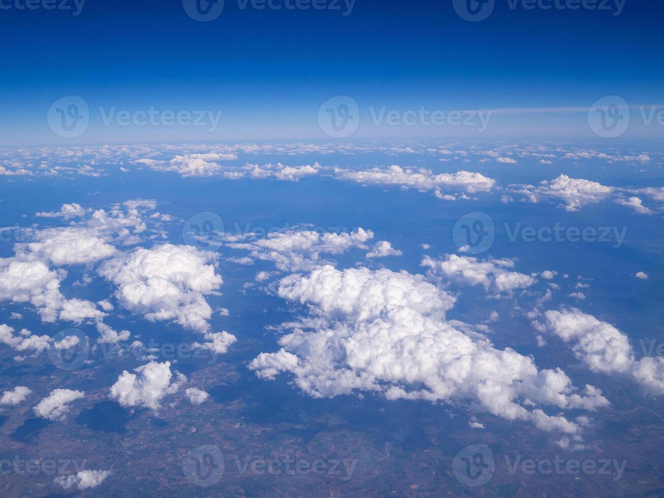Aerial view of lands and clouds seen through the airplane window photo
