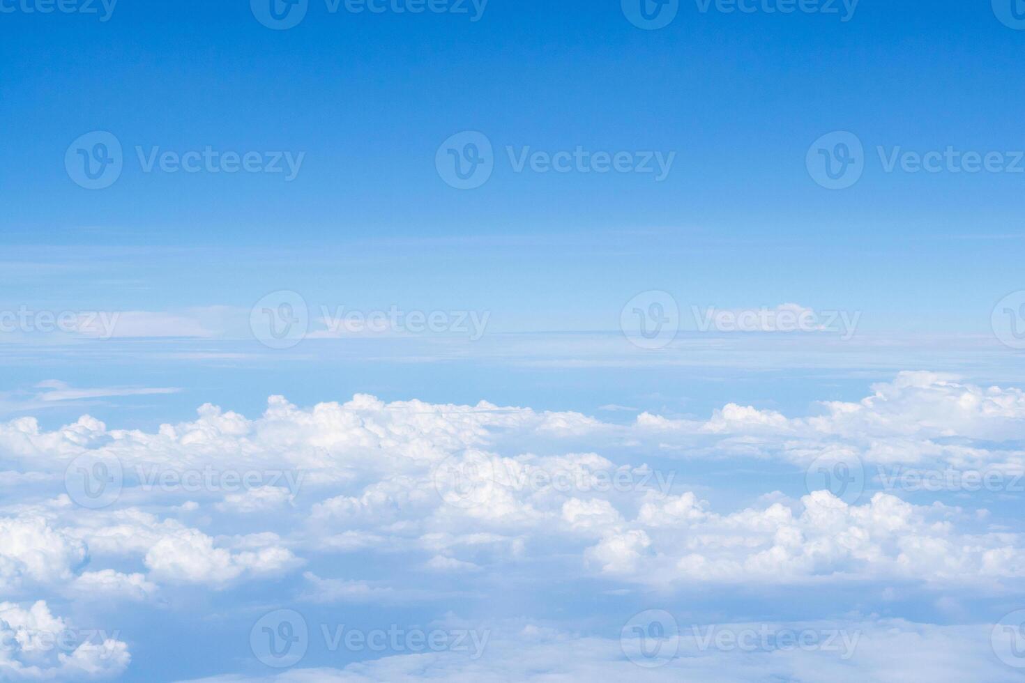 Aerial view of sky and clouds are seen through the airplane window photo