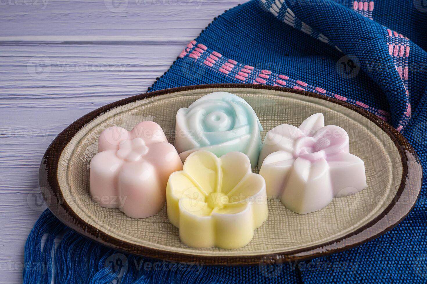 Top view of colorful coconut milk jelly on a plate on a blue cloth. Concept of Thai dessert photo