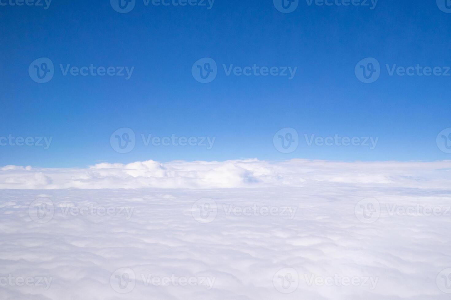 Aerial view of sky and clouds are seen through the airplane window photo