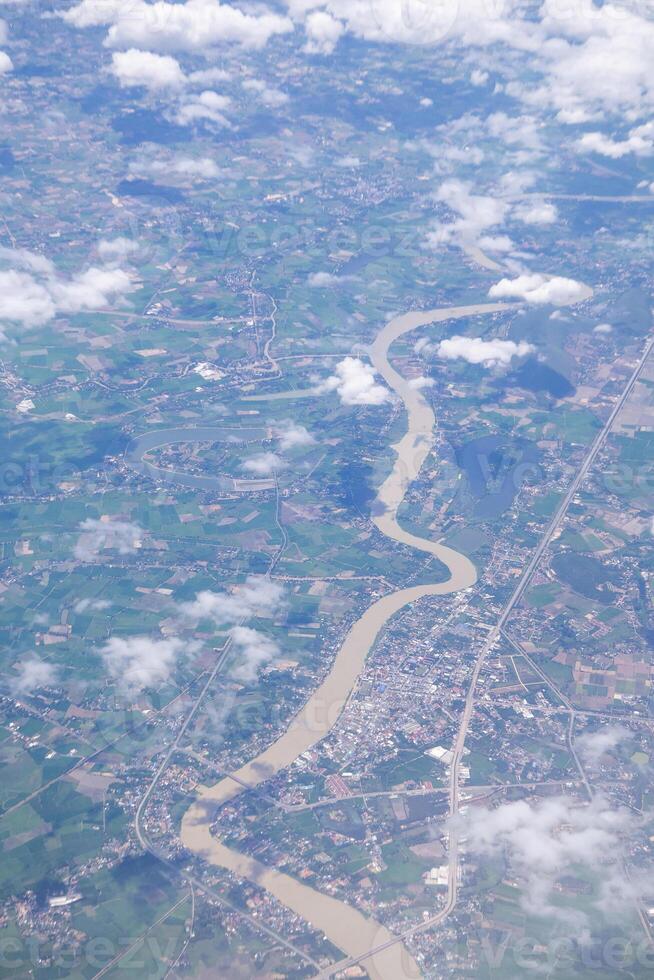 Aerial view of lands and clouds seen through airplane window photo
