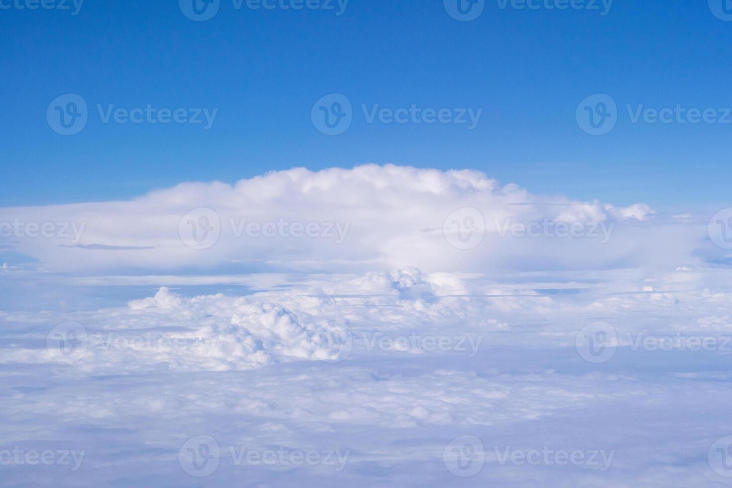 Aerial view of clouds and sky seen through the airplane window photo