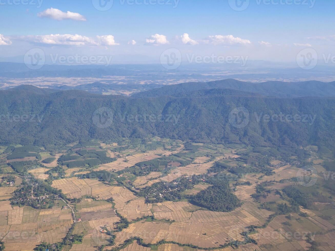 Aerial view of lands and clouds seen through the airplane window photo