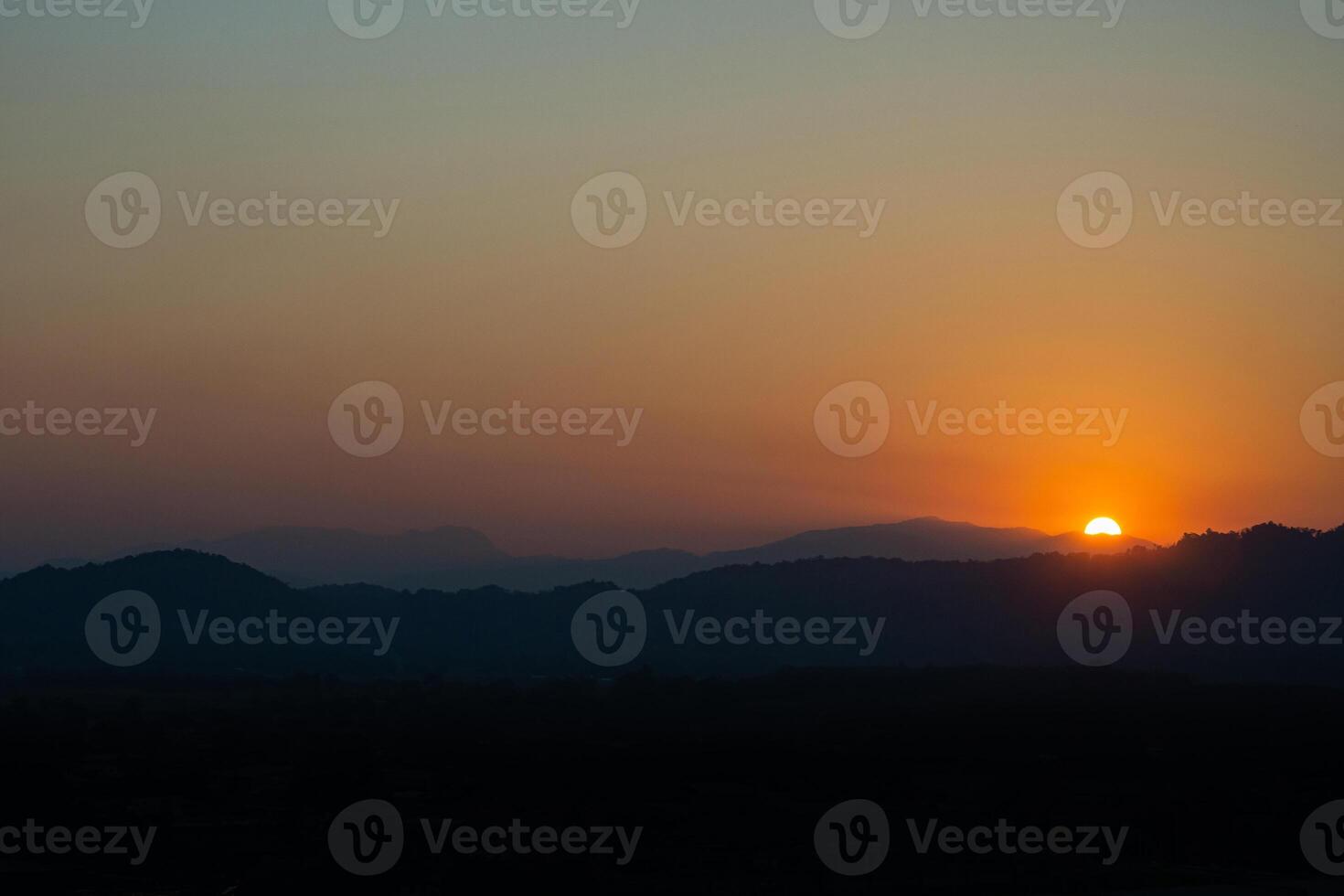 Beautiful dramatic sunset in the mountains. Landscape with sunlight shining through orange. Nature concept photo