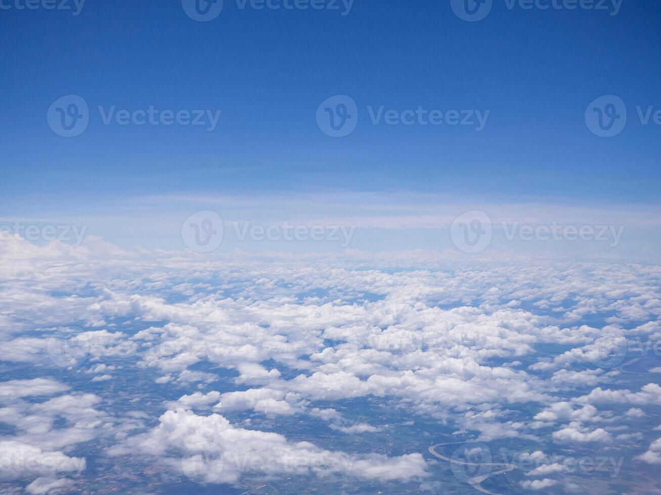 Aerial view of clouds and sky seen through the airplane window photo