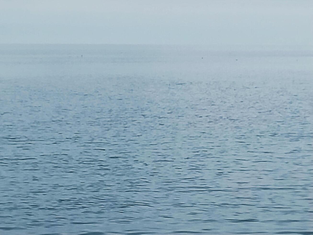 Calm sea texture. Light ripples on blue water photo