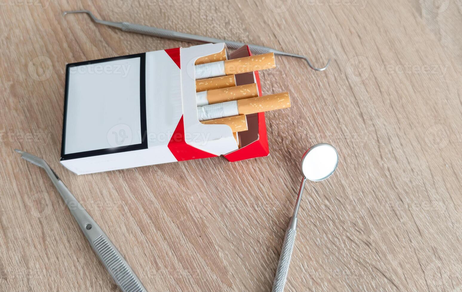 Image of dental tools with cigarettes on the table background photo