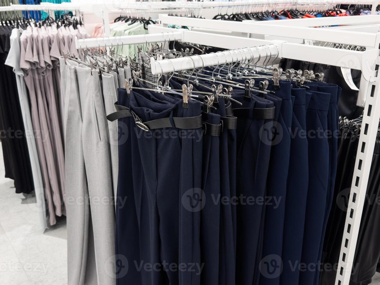 Row of hanged men Several different pants in a shop. Clothes store. photo