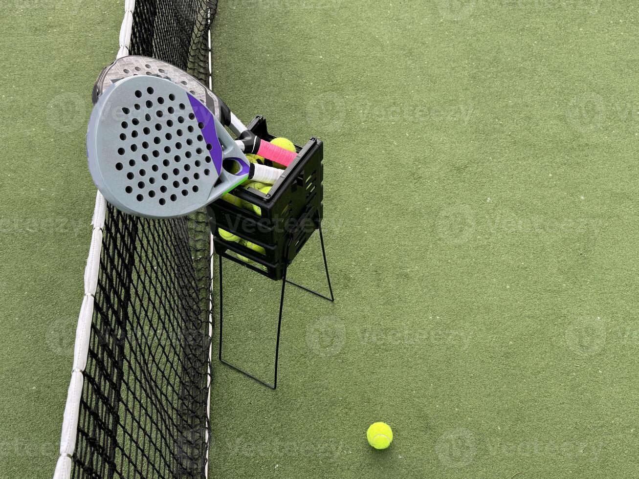 Background of padel racket and ball on artificial grass floor in outdoor court. Top view. photo