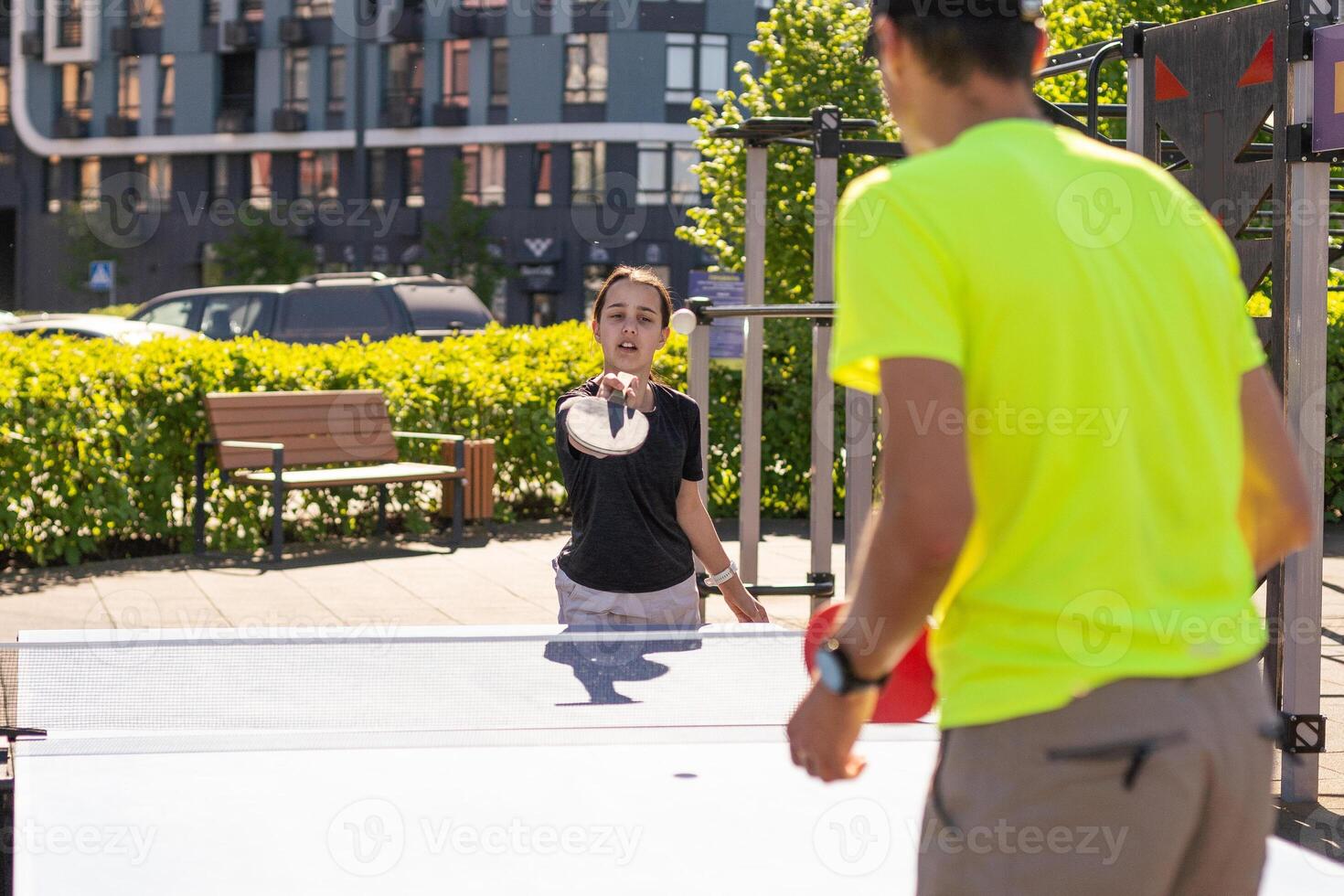 Family playing table tennis outside house photo
