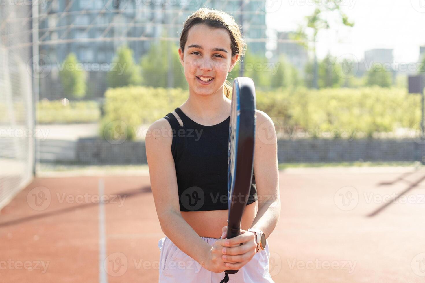 Padel tennis player with racket and ball in hands. Girl athlete with paddle racket on court outdoors. Sport concept. Download a high quality photo for the design of a sports app or web site.
