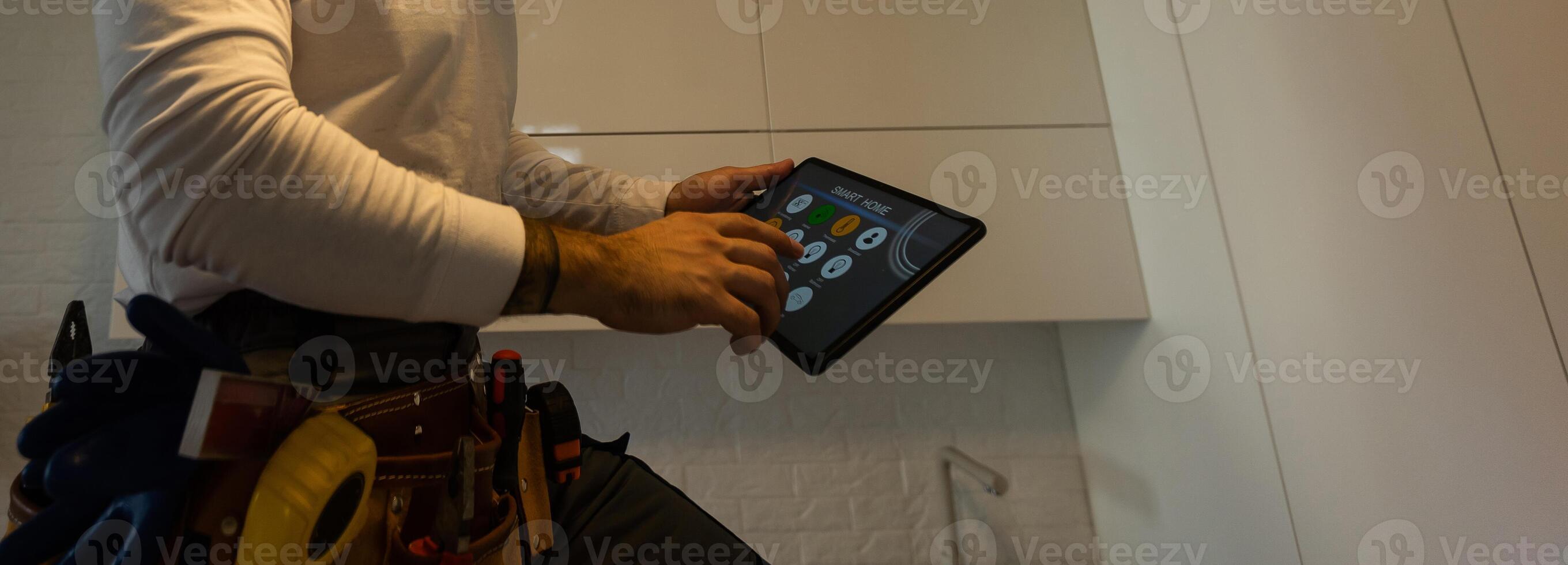 A worker looks at a tablet computer. Master with an electronic tablet in his hands photo