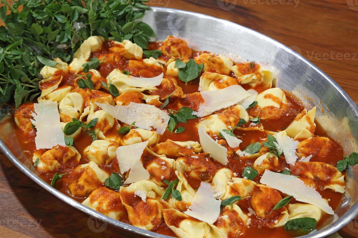 cheese ravioli with parmesan and basil in tomato sauce photo