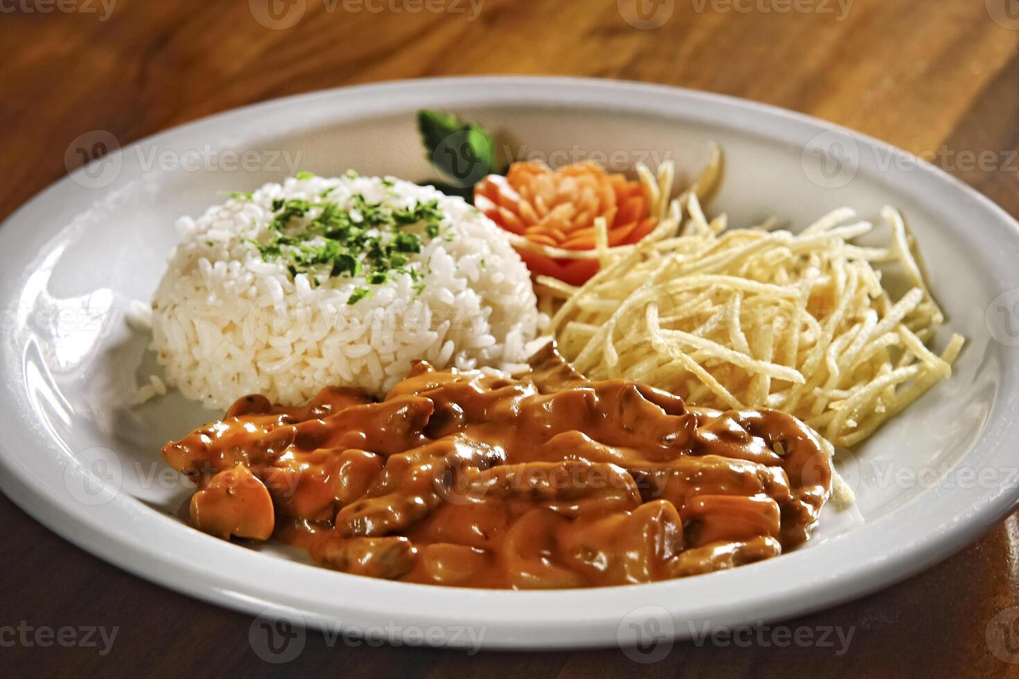delicious stroganoff with rice and french fries on plate photo