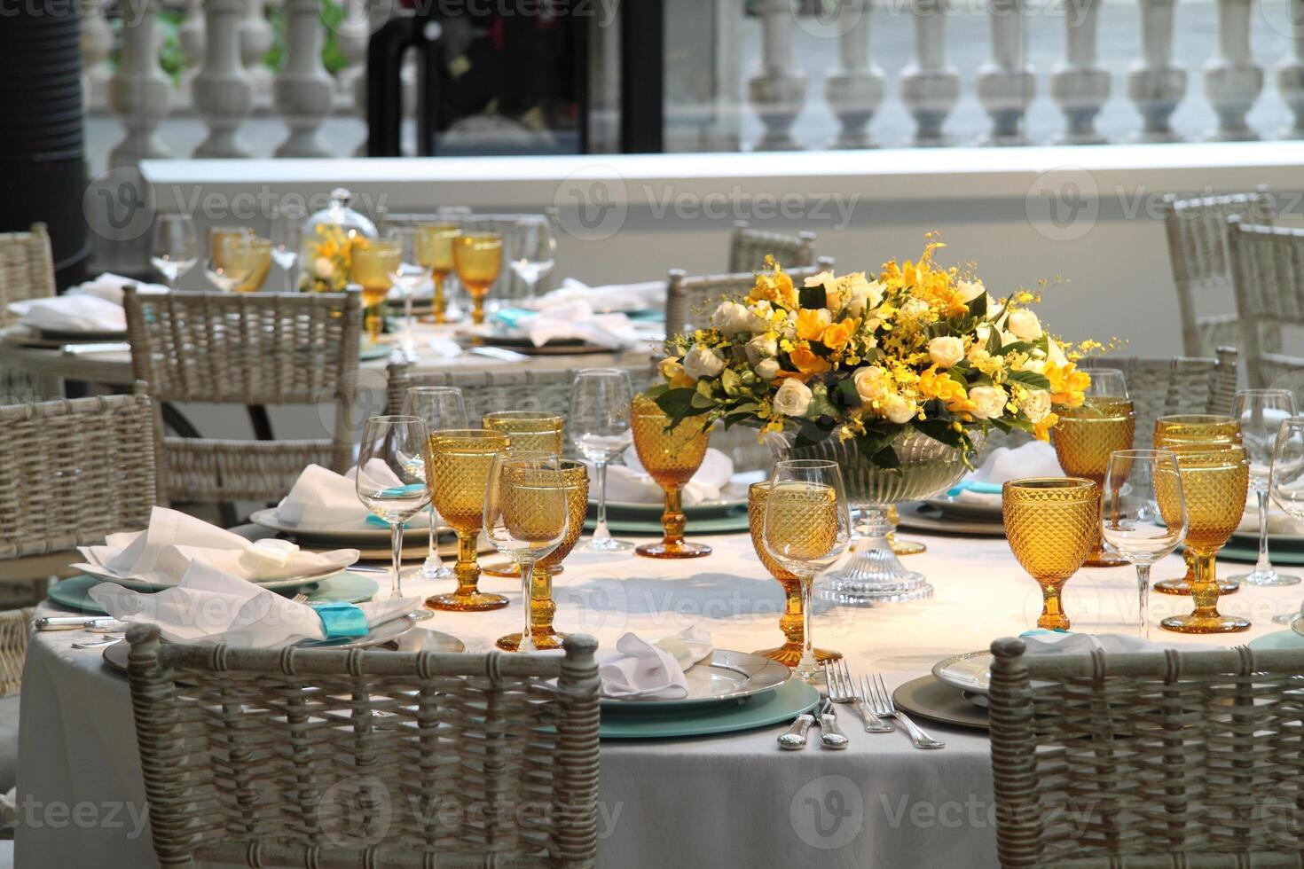 sophisticated lunch table setup in yacht club with plates, glasses, flowers and cutlery photo