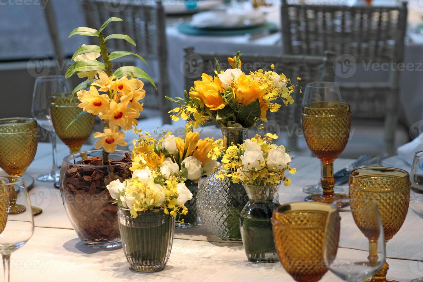 sophisticated lunch table setup in yacht club with plates, glasses, flowers and cutlery photo