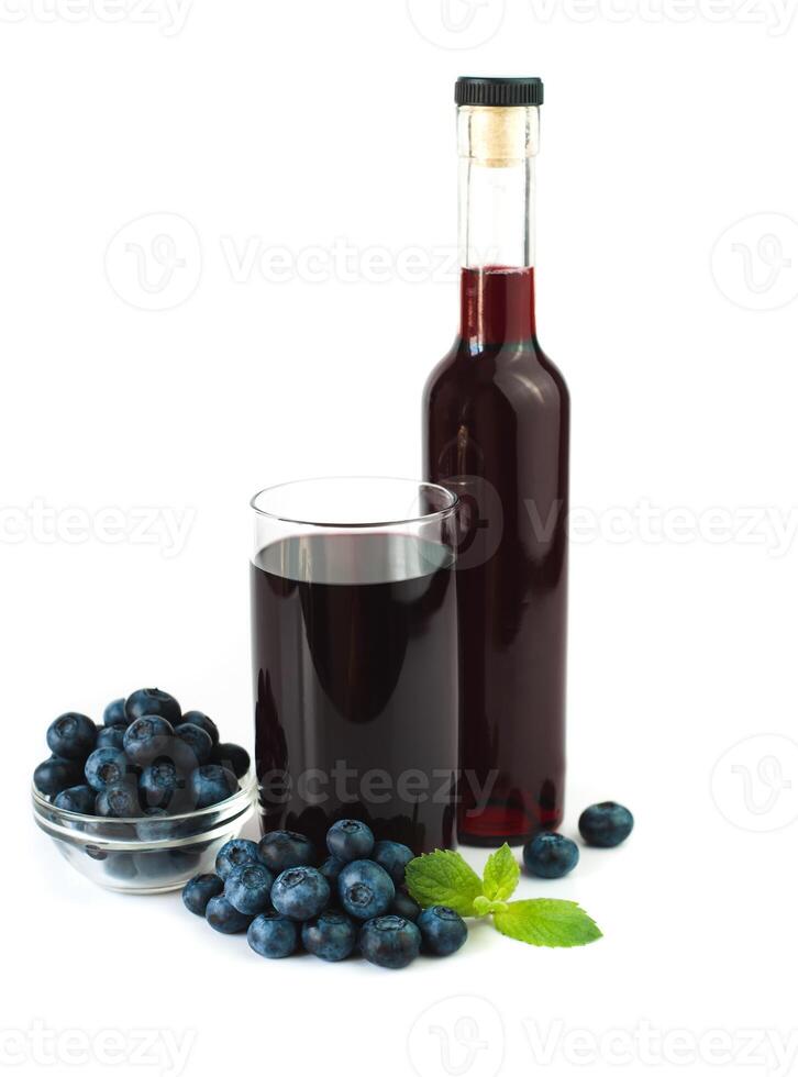 Fresh blueberry juice in a glass and ripe blueberries on a white background. Healthy, vitamin juices. Close-up. photo