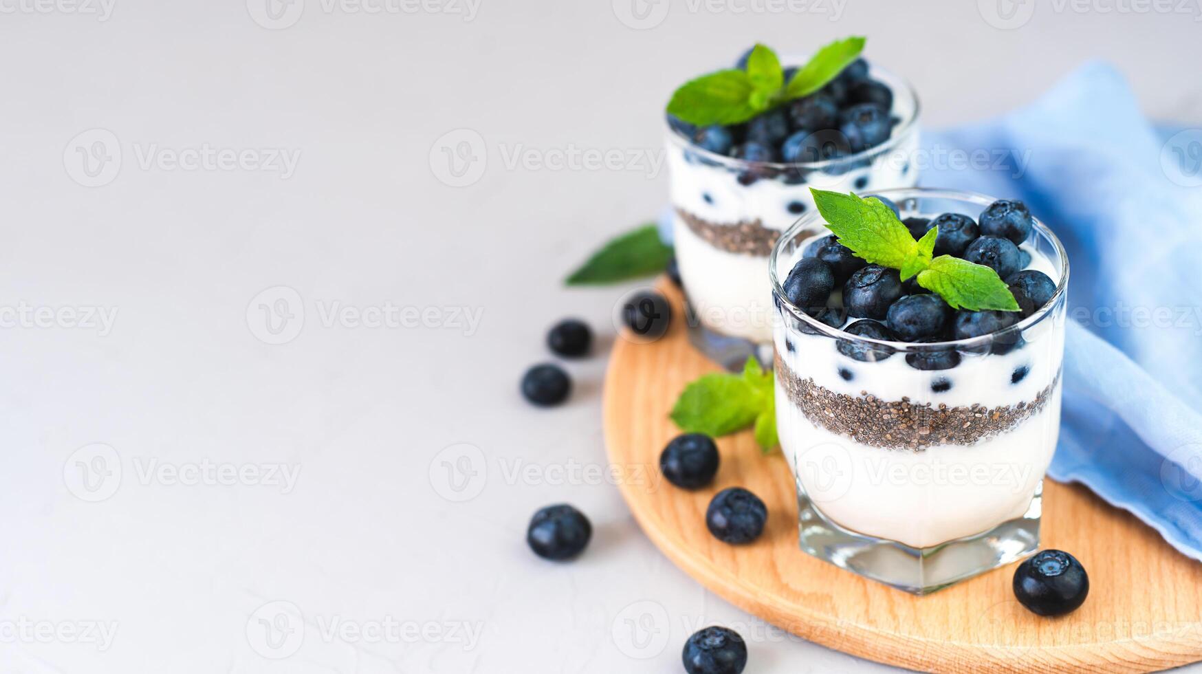 Delicious dessert of blueberries, yogurt and chia seeds for breakfast. Healthy food concept. Close-up. Place for text. photo