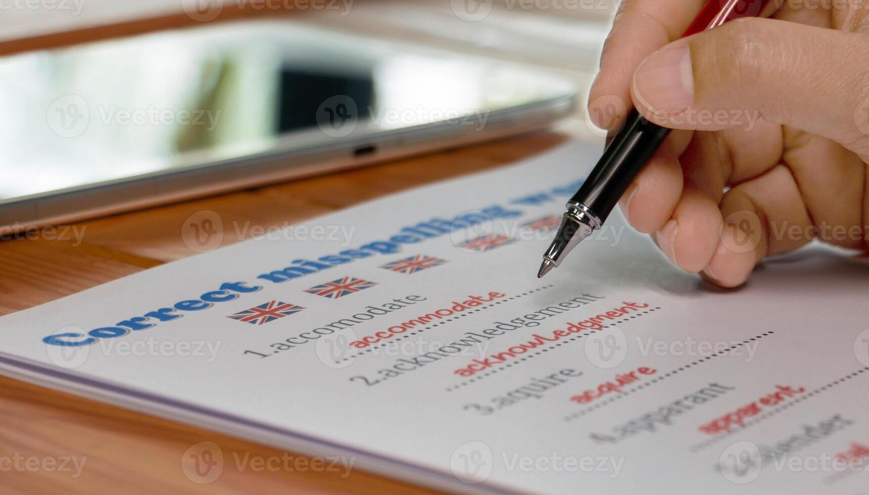 English misspelling worksheet with pen and tablet photo