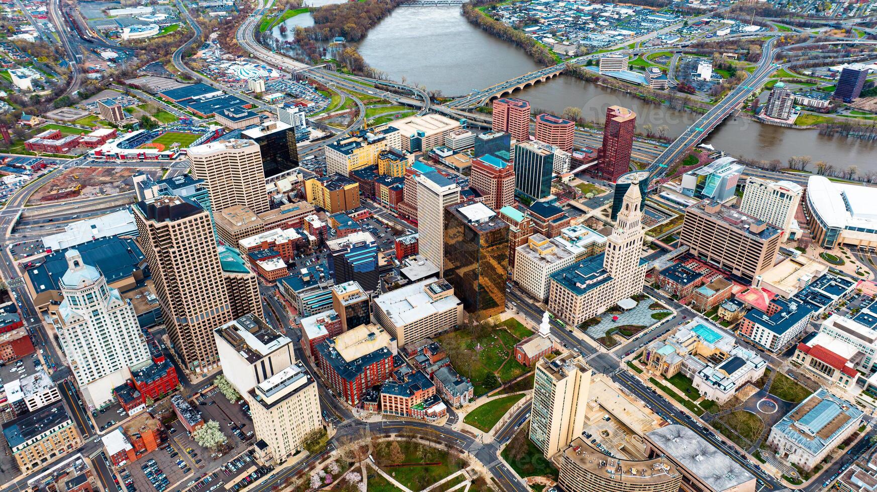 Downtown of beautiful modern Hartford, Connecticut, the USA at daytime. View on the river floating through the city at backdrop. Aerial perspective. photo