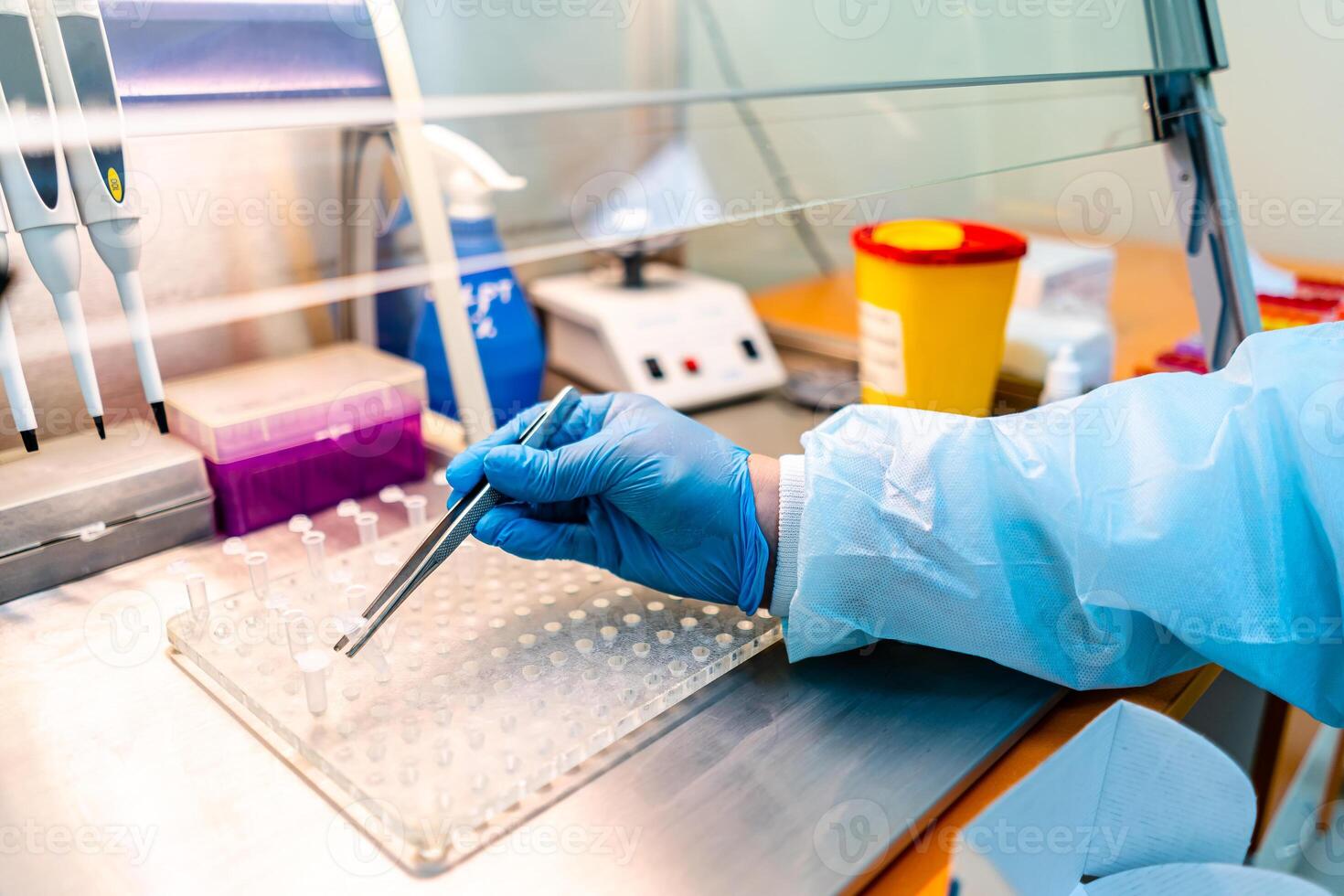 Hand in latex gloves uses tweezers to put probes on tablet. Laboratory concept of analazying blood and urine. closeup. photo