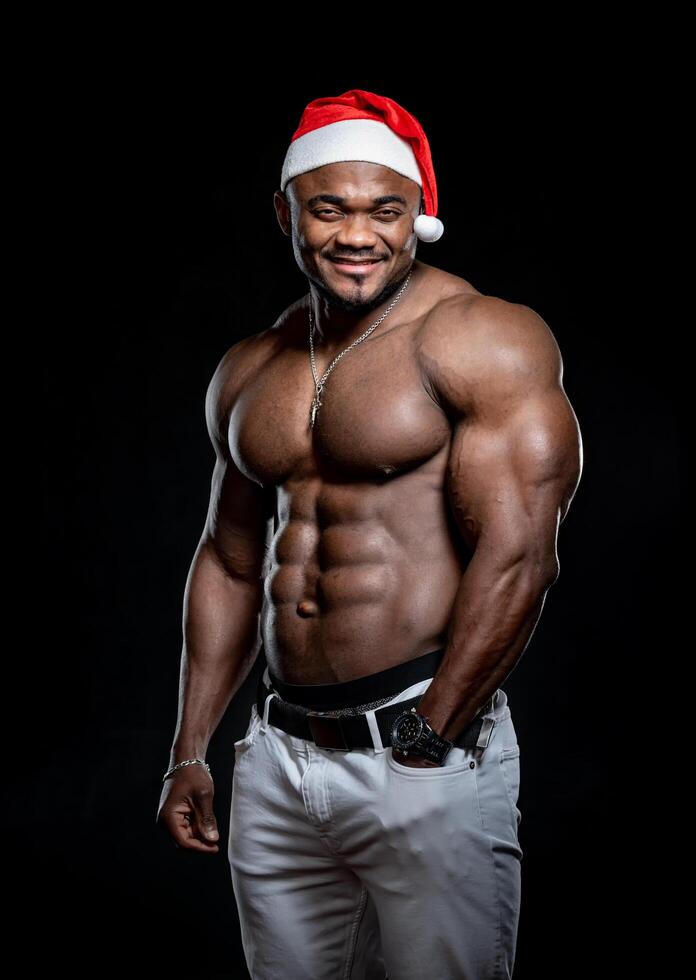 Sexy shirtless muscular man on dark background. Young strong macho. photo