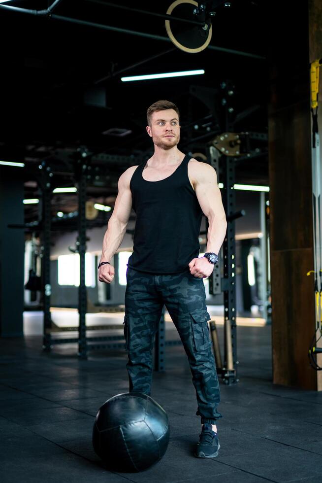 Handsome young man in gym. Fitness muscular man portrait. photo