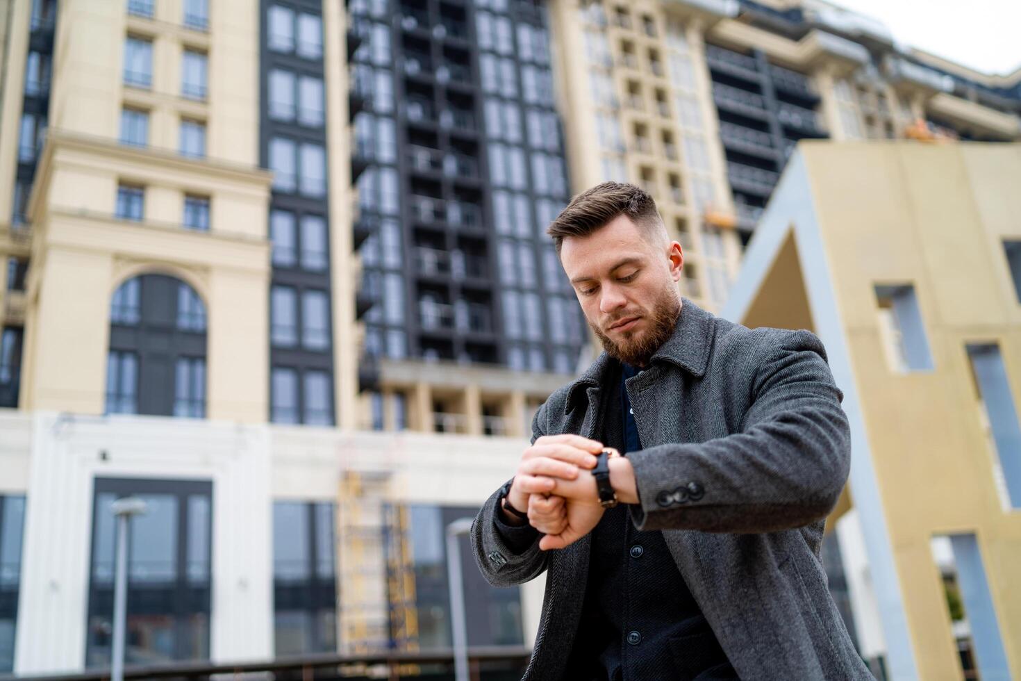 Attractive confident male in casual trendy cloth. Handsome stylish man standing on modern city street. photo