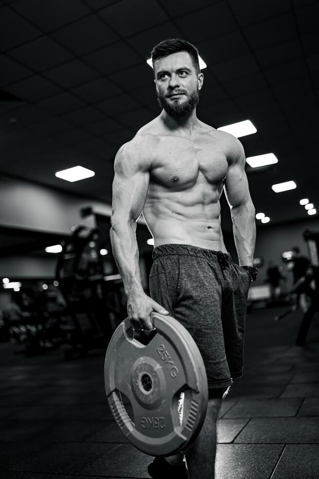 Fitness bodybuilding topless man in gym. Working out strong man. photo