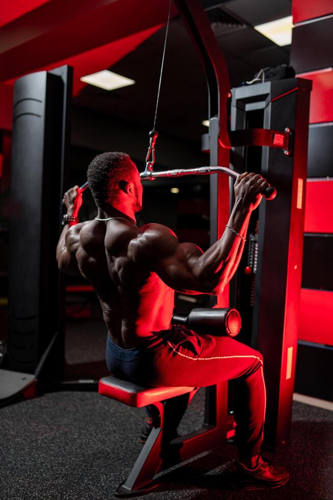 Handsome muscular man working out. Big strong bodyuilder in gym having rest. photo