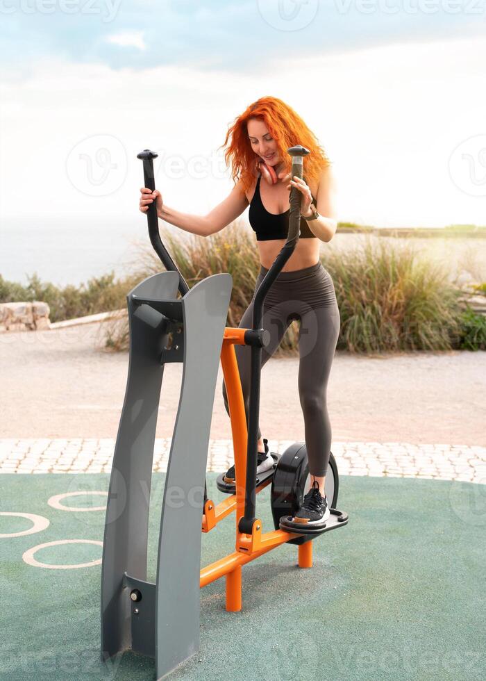 Happy woman athlete exercising at outdoor gym park photo