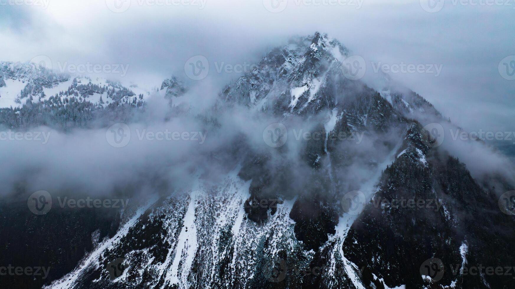 Mountain American nature with clouds. Clouds over forest of Mount Rainier park. photo