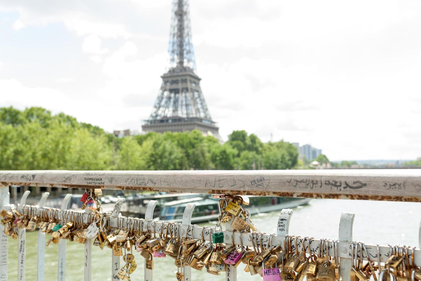 Paris, France, Europe - June 02, 2018 Padlocks on the Arts Bridge over the Seine River in Paris With Eifel tower on the background photo